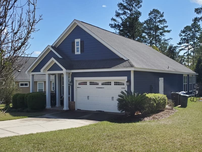 Exterior house painting in Tallahassee, navy fiber-cement siding repaint by Superior Painting